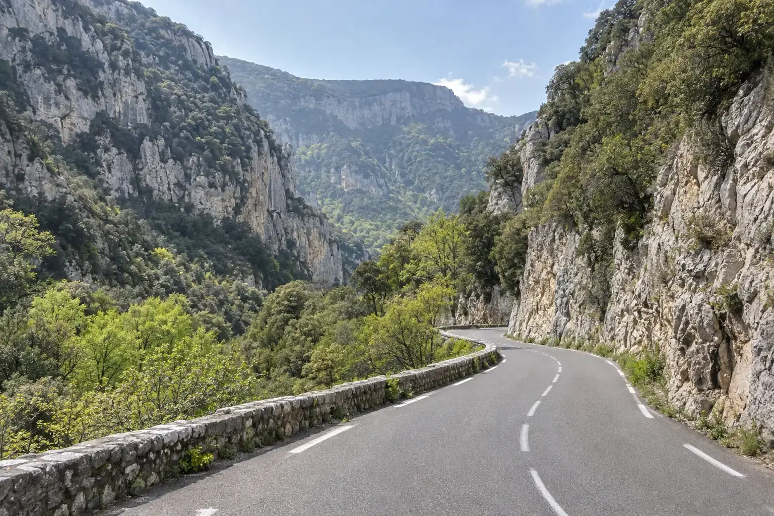 La route D943 dans la combe de Lourmarin, entre le Petit et le Grand Luberon, falaises calcaires et chênes verts