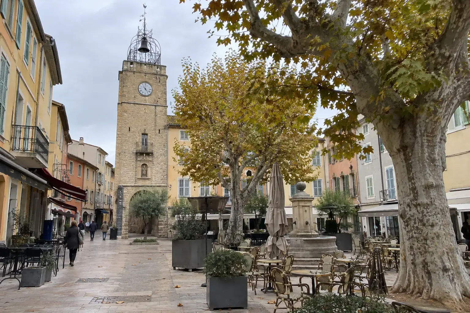 Une place du centre de Pertuis, le beffroi et son campanile de fer au fond, les platanes, un jour d’automne